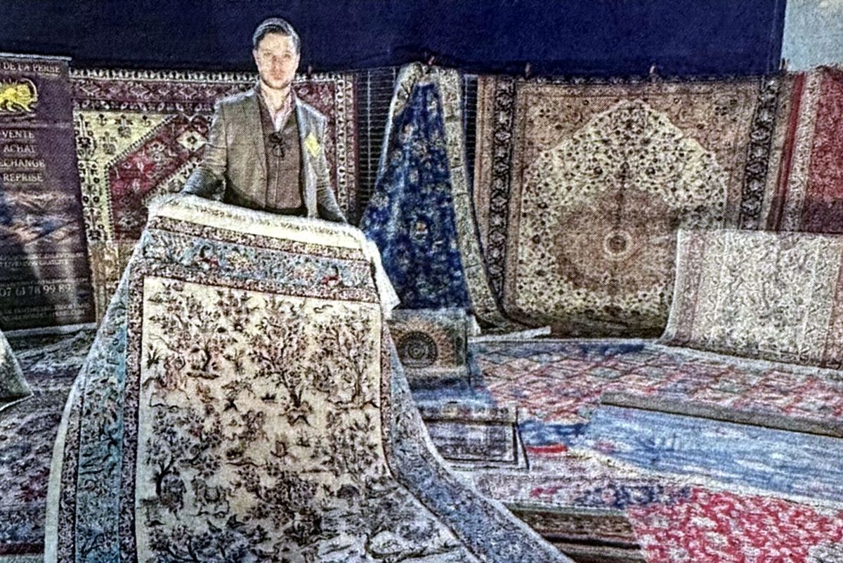 Adrien Mignaton présente un tapis en soie sur le stand de La Maison de la Perse