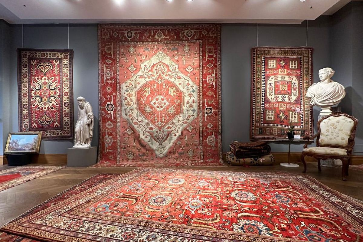 Tapis anciens persans et caucasiens accrochés aux murs et posés au sol, avec sculptures, tableau et fauteuil anciens